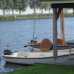 Bootjes aan de steiger van Huisje in IJsselmuiden, ideaal voor watersportliefhebbers in Noordwest Overijssel.