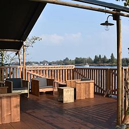 Geniessen Sie die Aussicht von der Terrasse des Huisje in Vinkeveen, einem Ferienhaus in Vinkeveen, Utrecht, umgeben von schoener Natur.