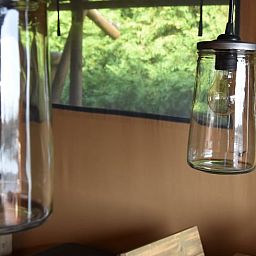 Stilvoller Innenraum des Huisje in Vinkeveen, Ferienhaus in Utrecht, mit moderner Beleuchtung und Blick auf die gruene Natur.