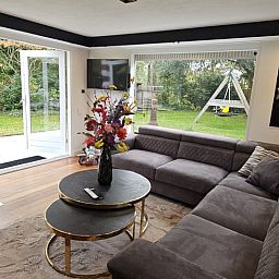 Gezellige woonkamer in Huisje in Vinkeveen, vakantieaccommodatie in Utrecht met uitzicht op de tuin.