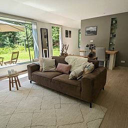 Stijlvolle woonkamer in Vakantiehuis in Soest met uitzicht op de groene natuur van Utrecht.