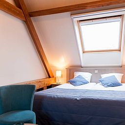 Sfeervolle slaapkamer in Vakantiehuisje in Vreeland, Utrecht noord met dakraam en comfortabele bedden.