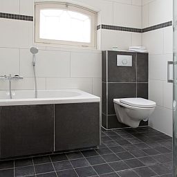 Moderne badkamer in Vakantiehuisje in Vreeland, Utrecht met ligbad en douche voor ultiem comfort.