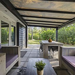 Geniessen Sie die geraeumige Veranda des Bungalows Schoonoord in Doorn, Utrechtse Heuvelrug. Perfektes Feriendomizil in gruener Umgebung.