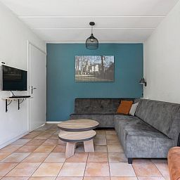 Gezellige woonkamer in Vakantiewoning Beukenrode, Doorn, Utrechtse Heuvelrug, met comfortabele zithoek en moderne inrichting.