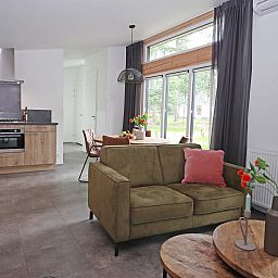 Gezellige woonkamer van Bungalow Molenstein in Doorn, Utrechtse Heuvelrug, met modern interieur en uitzicht op de groene omgeving.