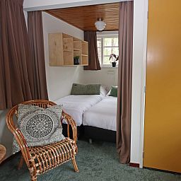 Interieur van Bungalow Ficus, Doorn, Utrechtse Heuvelrug, met gezellige slaapkamer en zithoek.