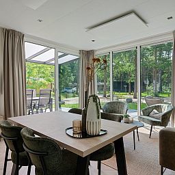 Bright living space in Bungalow Noordhout, Doorn, with large windows and nature view of the Utrechtse Heuvelrug.