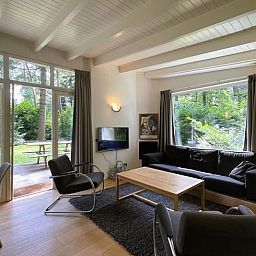 Cozy living room of Holiday Home in Maarn, Utrechtse Heuvelrug, overlooking the green garden.