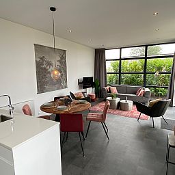 Stylish living room of Chalet in Maarn, Utrechtse Heuvelrug, with modern decor and large windows offering views of nature.