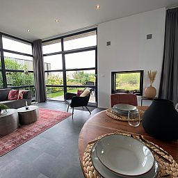 Helles Wohnzimmer eines freistehenden Hauses in Maarn, Utrechtse Heuvelrug, mit moderner Einrichtung und Blick auf den Garten.