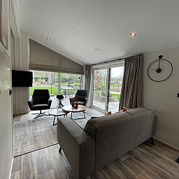 Cozy living room of the detached house in Maarn, Utrechtse Heuvelrug, overlooking the green garden and comfortable seating area.