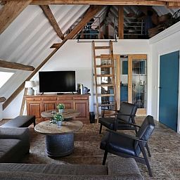 Moderne trap en wasruimte in Vakantiehuisje in Achterveld, Utrechtse Heuvelrug, met houten en metalen elementen.