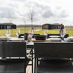 Die Aussenterrasse des Ferienhauses in Wissenkerke bietet einen Panoramablick auf die gruene Umgebung von Nord-Beveland, Zeeland.