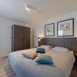 Comfortable bedroom in Holiday Home Ganuenta, Colijnsplaat, Noord-Beveland with ensuite bathroom.