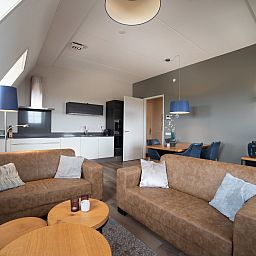 Stilvolles Wohnzimmer im Apartment Ganuenta, Colijnsplaat, Noord-Beveland, mit modernen Moebeln und offener Kueche.
