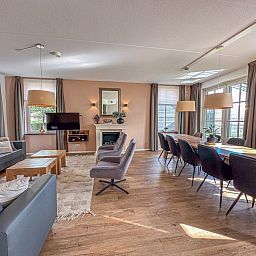 Ruime woonkamer van vakantiehuis Dune Design 39 in Colijnsplaat, Noord-Beveland, Zeeland met comfortabele zithoek en grote eettafel.