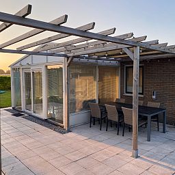 Gemuetliche Veranda im Ferienhaus ZE1679 in Kamperland, Noord-Beveland, Zeeland mit grossem Esstisch und Gartenblick.