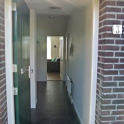 Entspannen Sie sich auf der Terrasse des Ferienhauses ZE1679 in Kamperland, Nord-Beveland, mit schoener Aussicht auf den gruenen Garten und die natuerliche Umgebung.