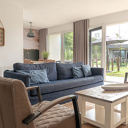 Gezellige woonkamer van Bungalow de Boei met uitzicht op de tuin in Kamperland, Noord-Beveland, Zeeland.