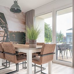 Stijlvolle eetruimte in Bungalow de Boei, Kamperland, met uitzicht op de natuur van Noord-Beveland, Zeeland.