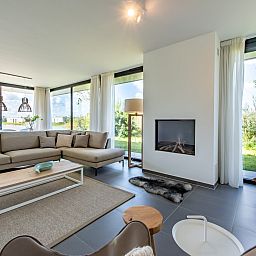 Ruime woonkamer met open haard in Duinvallei 32, vakantiehuis in Kamperland, Zeeland.