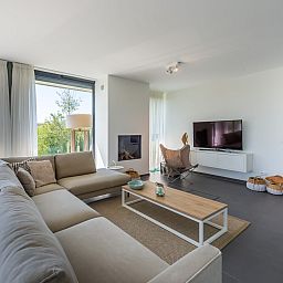 Comfortabele zithoek met groot raam in Duinvallei 32, vakantiehuis in Kamperland, Zeeland.