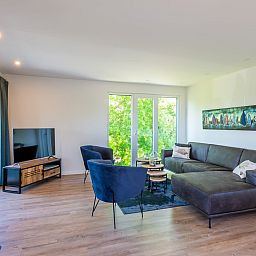 Stylish living room in vacation home Kastanjelaan 2 | Ruiterplaat, Kamperland, with comfortable seating area and views of nature.