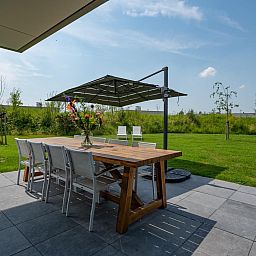 Aussenterrasse von Waterline 25 | De Groote Duynen, Ferienhaus in Kamperland, Noord-Beveland, mit grossem Esstisch und Sonnenschirm.