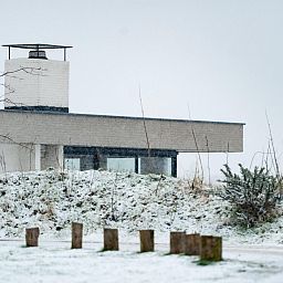 Winteransicht von Duinvallei 43, Bungalow in De Groote Duynen, Kamperland, umgeben von Schnee.
