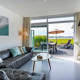 Comfortabele woonkamer in VZ2312 Vakantiehuis in Kamperland met zicht op het terras, Noord-Beveland, Zeeland.