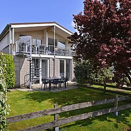 Buitenterras van Ostrea 106 in Roompot Beach Resort, Kamperland omgeven door groen in Noord-Beveland, Zeeland.