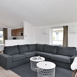 Ruime woonkamer van Ostrea 106 in Roompot Beach Resort, Kamperland met comfortabele bank in Noord-Beveland, Zeeland.