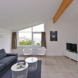 Gezellige zithoek in Ostrea 106, Roompot Beach Resort, Kamperland met open haard in Noord-Beveland, Zeeland.