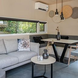 Gezellige binnenruimte van Lodge 4 in Kamperland, Noord-Beveland, met een moderne zithoek en uitzicht op de natuur van Zeeland.