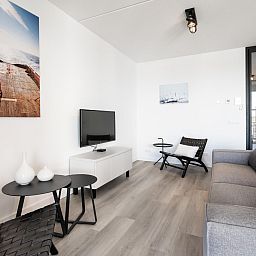 Gezellige binnenruimte in Harbour Loft 1E, Residence Marina, met comfortabele meubels.