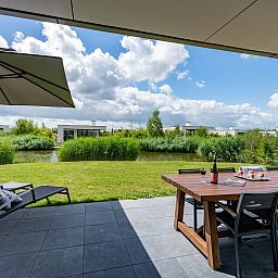 Relax on the veranda of Duinvallei 10 | De Groote Duynen in Kamperland, a luxury vacation home surrounded by the tranquility of Zeeland.