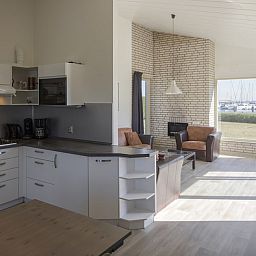Helles Wohnzimmer und Kueche in BA-Bungalow, Kamperland, Noord-Beveland, Zeeland, mit Blick auf den Yachthafen und moderner Einrichtung.