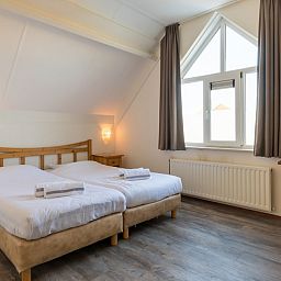 Moderne badkamer in Villa 5B, een vakantiehuis in Kamperland, Noord-Beveland, met ligbad en strak design voor ultiem comfort.