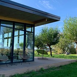 Terrace of vacation home in Kamperland with comfortable chairs and views of green surroundings in North Beveland, Zeeland.