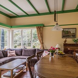 Gemuetliches Wohnzimmer im Ferienhaus in Burgh-Haamstede mit Blick auf den Garten in Zeeland.