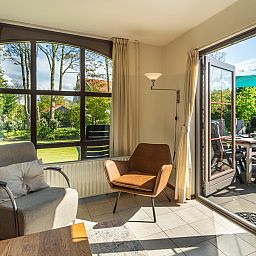 Cozy sitting area in Holiday home Schouwse Duin 35, Burgh-Haamstede, overlooking the garden in Zeeland.