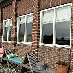 Gemuetlicher Innenraum mit Esstisch und Buecherregalen im Cottage in Bruinisse, Zeeland.