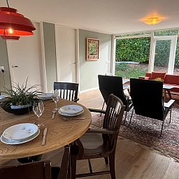 Gezellige binnenruimte van Vakantiewoning Het Ongerepte 21 'Kaatje Mossel' in Renesse, Zeeland, met eetgedeelte en uitzicht op de tuin.