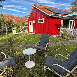 Vakantiewoning Het Ongerepte 21 'Kaatje Mossel' in Renesse, Zeeland, met zonnig terras en groene tuin voor een ontspannen verblijf.
