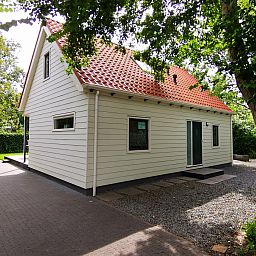 Seitenansicht des Ferienhauses Duinweg 12 in Renesse, umgeben von Natur in Zeeland.