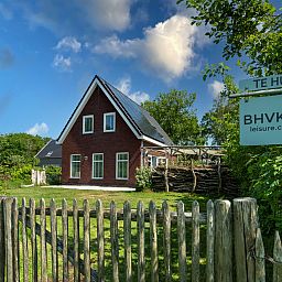 Ferienhaus De Zuidhoek 6 in Renesse, eingezaeunt mit Holzzaun und gruener Umgebung.