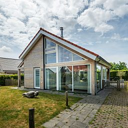 Seitenansicht des Ferienhauses Zonnedorp 8, De Zeehond in Renesse, Zeeland mit einem gepflegten Garten.