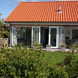 Gruener Garten des Ferienhauses Zonnedorp 12 Jolie in Renesse, Zeeland mit moderner Veranda.