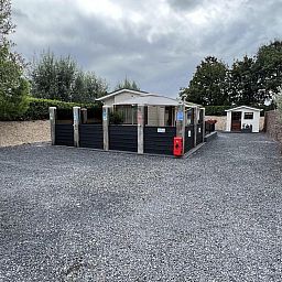 Ruime buitenruimte bij VZ2321 Vakantiechalet in Renesse, omgeven door groen in Zeeland.